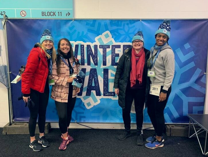 four girls in scarves in front of winter walk event