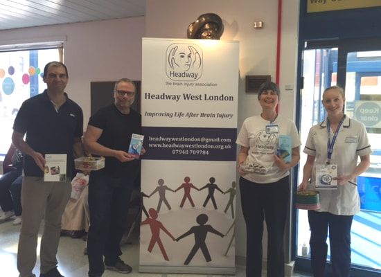 four team members with Headway poster